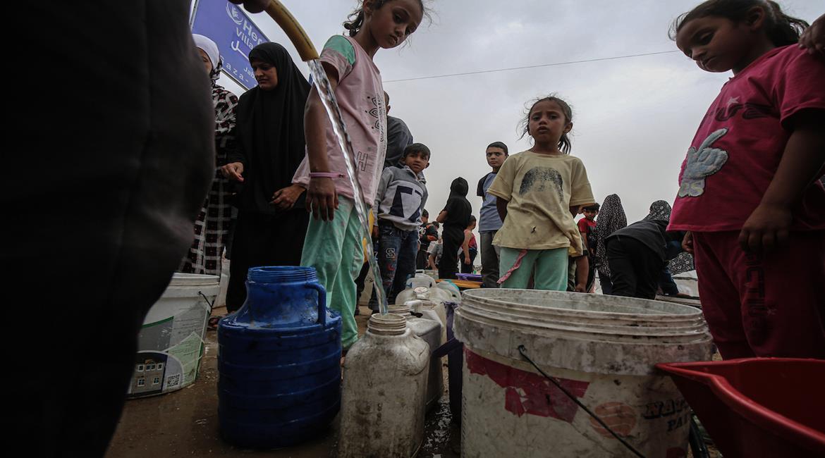 مواطنون يتجمعون للحصول على مياه الشرب في مخيم جباليا المدمر شمال قطاع غزة