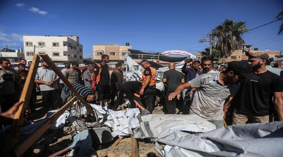  مواطنون يتفقدون موقع غارة اسرائيلية على خيمة داخل مستشفى شهداء الأقصى في دير البلح وسط قطاع غزة