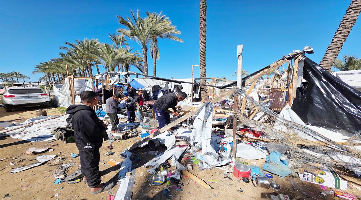 مواطنون يتفقدن الدمار بخيام النازحين بعد استهداف الاحتلال لخيمة تأوي نازحين في مواصي خان يونس