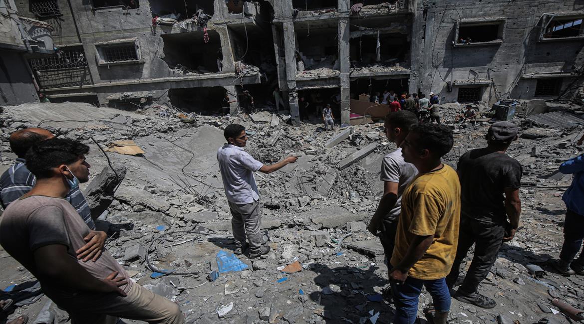 مواطنون يتفقدون آثار الدمار الذي خلفته غارة جوية إسرائيلية استهدفت منازل المواطنين في مدينة غزة.