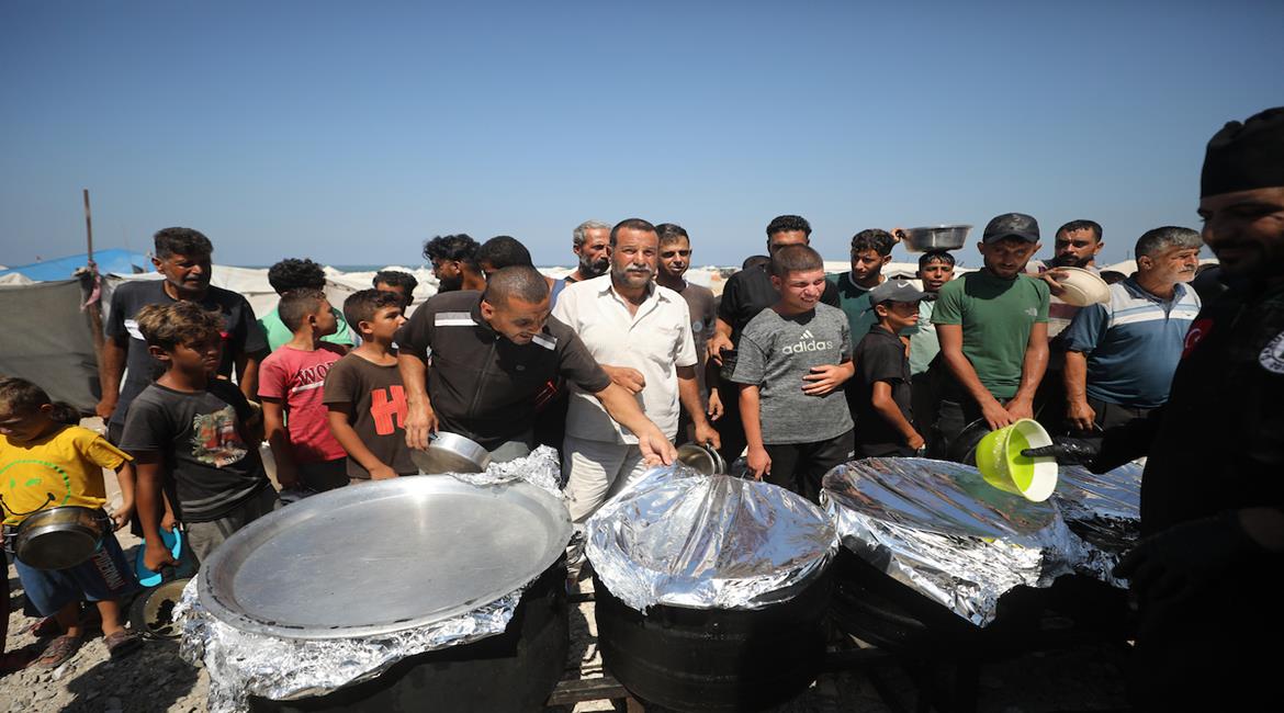 نازحون يتلقون وجبات طعام مجانية تُوزع غرب مدينة غزة، وسط ظروف إنسانية صعبة ونقص في المواد الغذائية والاحتياجات الأساسية