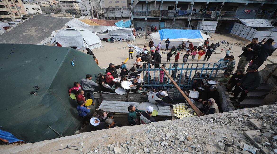 نازحون يتجمعون للحصول على وجبات طعام من تكية خيرية خلال شهر رمضان في مدينة غزة