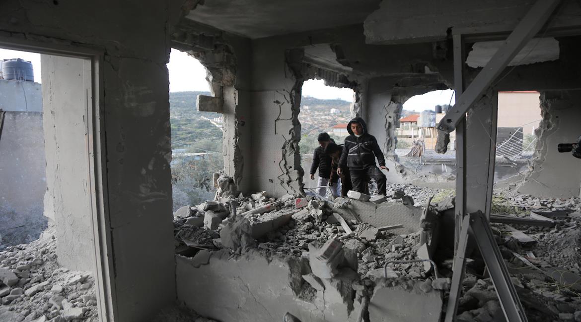 مواطنون يتفقدون منزلًا بعد هدمه من قبل قوات الاحتلال في بلدة قباطية جنوب جنين