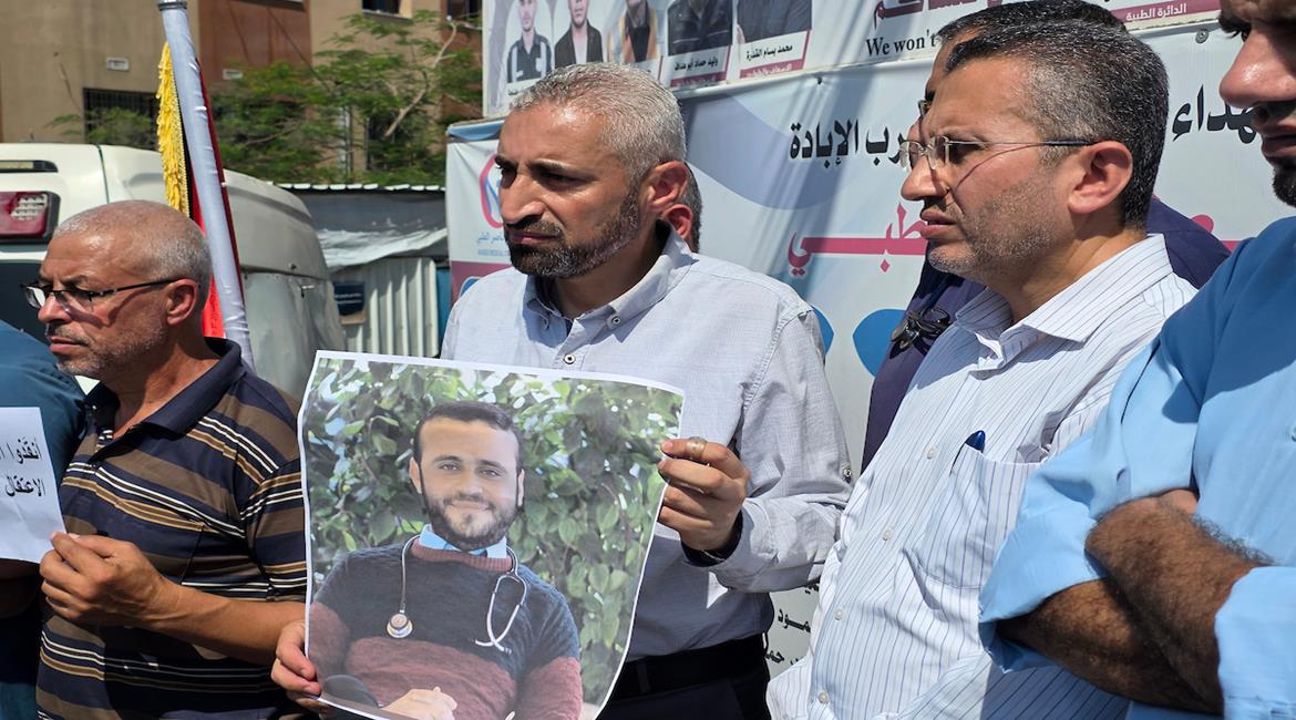 أطباء وعاملون في القطاع الصحي، يشاركون في وقفة بمجمع ناصر الطبي في خان يونس، للمطالبة بالإفراج عن الكوادر الطبية المحتجزة في السجون الإسرائيلية