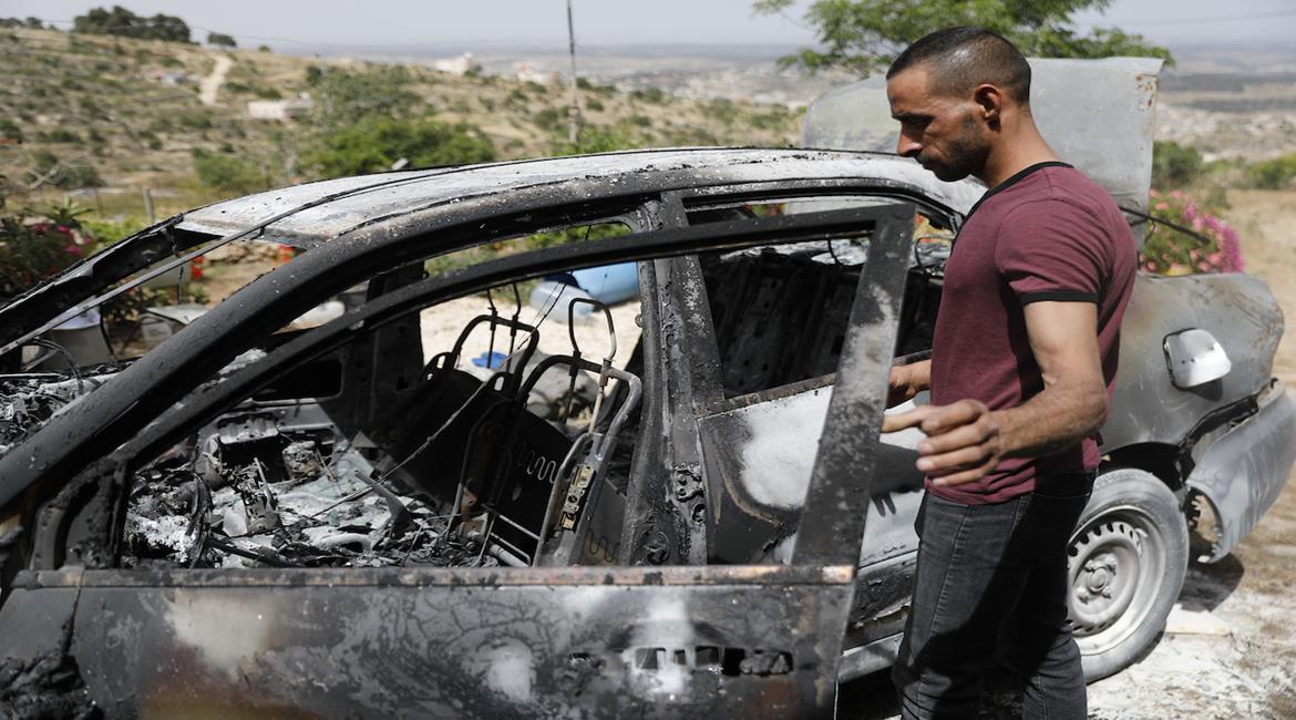 مواطنون يتفقدون مركبات وممتلكات أُحرقت على يد مستعمرين بعد هجومهم على بلدة صوريف شمال غرب الخليل