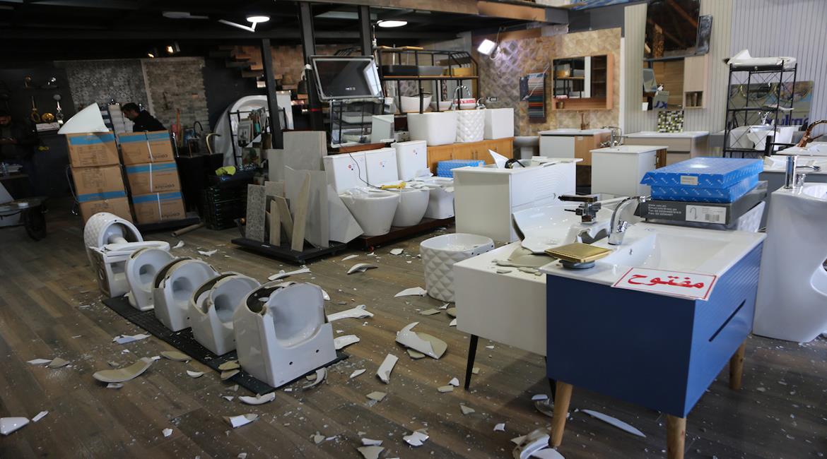 مواطنون يتفقدون أحد المحال التجارية بعد ان قامت مجموعة من المستعمرين بمهاجمته وتخريبه في قرية دير شرف غرب مدينة نابلس