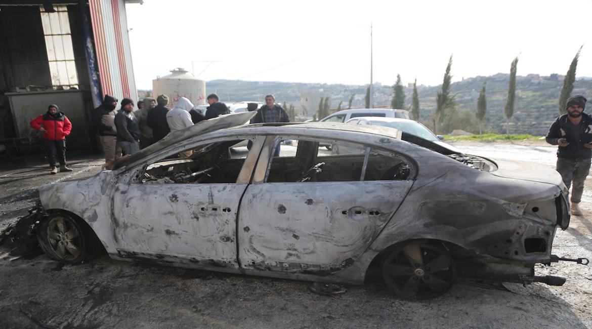 مواطنون يتفقدون الأضرار التي لحقت بمركباتهم، بعد أن أضرم مستعمرون النار فيها خلال هجوم على قرية عوريف جنوب نابلس