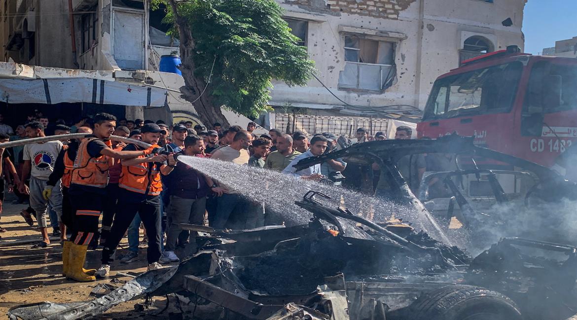 مواطنون يتجمعون في موقع غارة جوية إسرائيلية استهدفت مركبة في حي تل الهوى جنوب غرب مدينة غزة