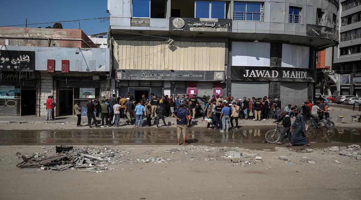 مواطنون يصطفون في طوابير امام احد البنوك المصرفية في مدينة غزة , بعد ان اغلقت خلال الفترة السابقة بسبب استمرار الحرب الاسرائيلية على قطاع غزة