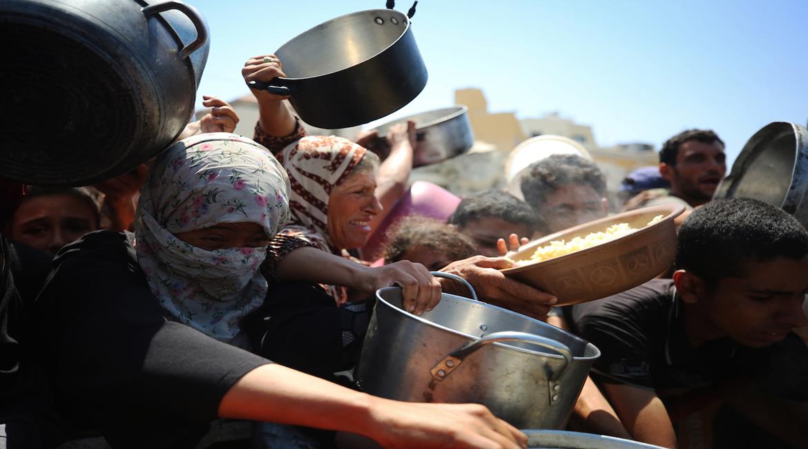 مواطنون يتجمعون للحصول على الطعام المجاني من تكية خيرية في مدينة غزة