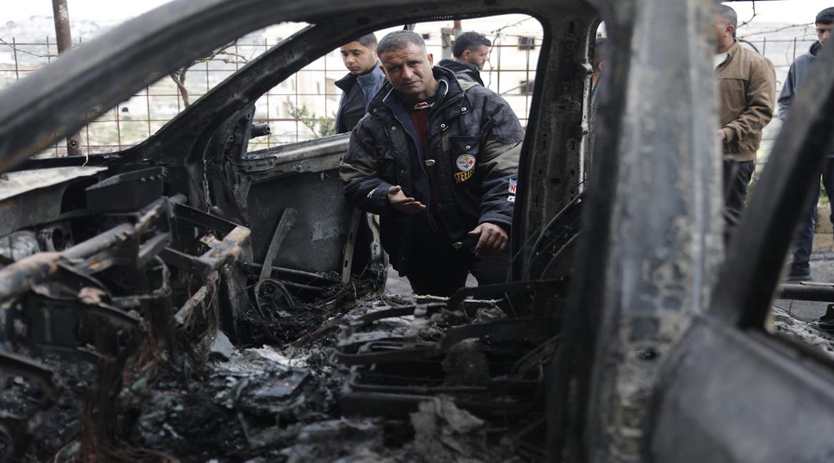 مواطنون يتفقدون مركباتهم التي أحرقها مستعمرين خلال هجومها على منطقة الرهوة في سعير شمال شرق الخليل.