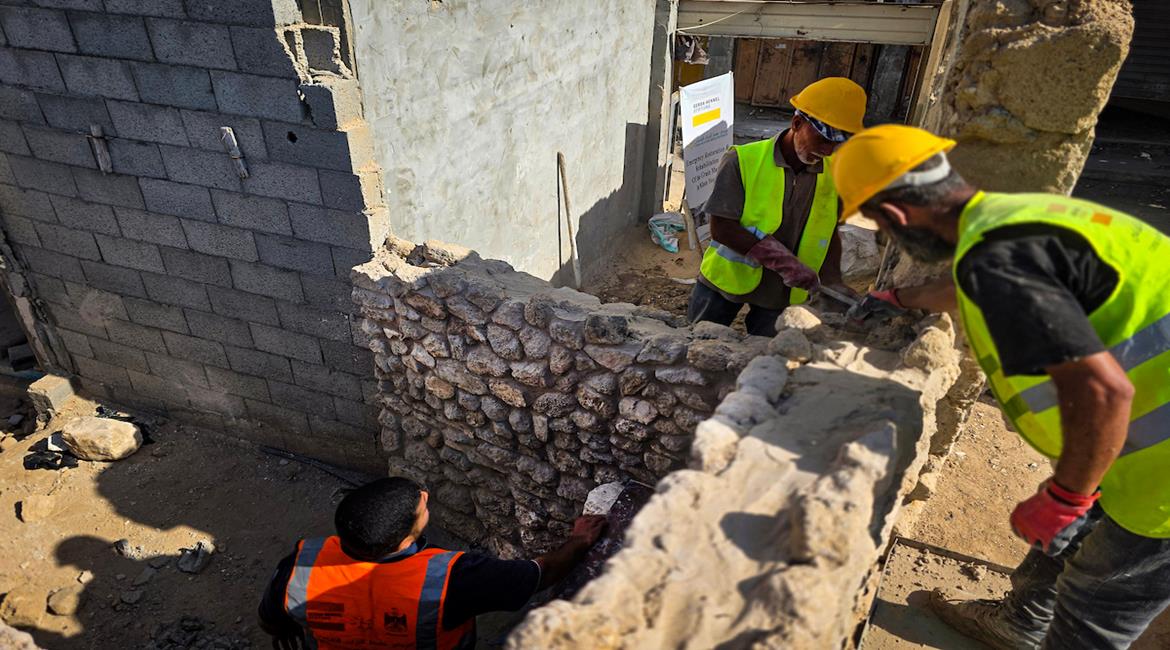 عمال يشاركون في أعمال تأهيل سوق الحبوب التاريخي في خان يونس جنوب قطاع غزة، حيث يجري إعادة بناء أربعة محال باستخدام حجارتها الأصلية، ضمن مشروع للحفاظ على الطابع التاريخي للسوق ودعم عودة النشاط الاقتصادي إلى المنطقة