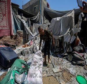 غزة - مواطنون يتفقدون الدمار جراء القصف الإسرائيلي للخيام التي تأوي النازحين بالقرب من مستشفى الشفاء الطبي في مدينة غزة