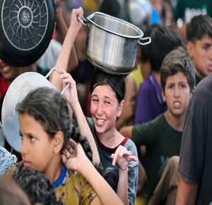 غزة - مواطنون يتجمعون للحصول على الطعام المجاني من تكية خيرية في النصيرات وسط قطاع غزة