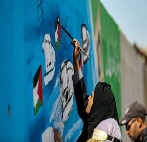 غزة - فنانون يرسمون جداريات في دير البلح ترحيبا بأسطول الصمود العالمي الذي منعه الاحتلال من الوصول إلى غزة